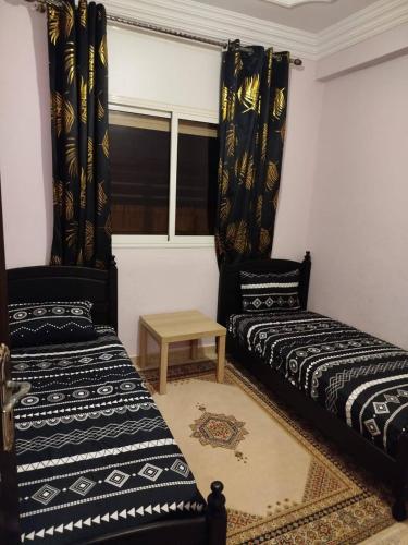 a room with two beds and a window at A nice appartement a louer temara in Temara