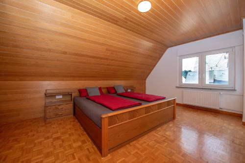 a bed in a room with a wooden ceiling at Ferienwohnung Moselblick Zell-Merl - Merllorca DG Panoramablick & Parkplatz in Zell an der Mosel