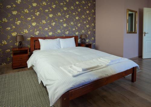 a bedroom with a large bed with white sheets at Fazenda in Sumy