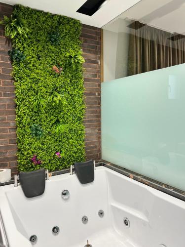 eine Badewanne im Bad mit grüner Wand in der Unterkunft Suite apartment in Korçë