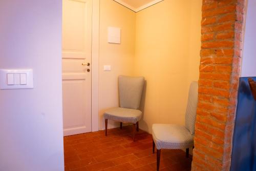 a room with two chairs and a door at Le Chiome in San Giovanni Alla Vena