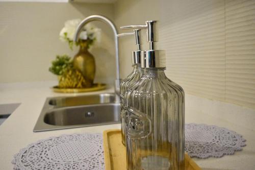 a glass bottle on a kitchen counter next to a sink at Nala Host- Sea Breeze 1BR apartment in Hulhumale