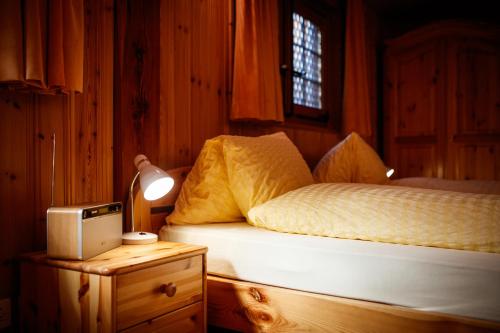 a bedroom with a bed and a table with a lamp at Hotel Nufenen in Ulrichen