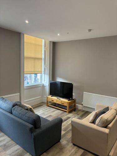 a living room with two couches and a flat screen tv at George IV Bridge Suite in Edinburgh