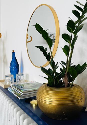 a gold vase sitting on a table with a mirror at Le 8 in Mutzig