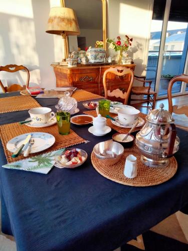 a table with a blue table cloth with a tea set at Chambre d'hôtes Coeur de Maine in Angers