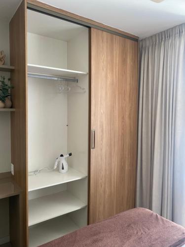 a bedroom with a closet with a bed and a window at Apto novo perto da UFF e Plaza in Niterói