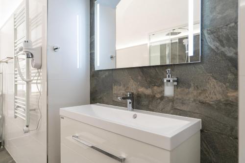 a bathroom with a white sink and a mirror at Hotel Arkada in Levoča