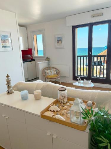 a living room with a couch and a table at Cote et Mer Superbe appartement Front de Mer WIFI & PARKING in Villers-sur-Mer