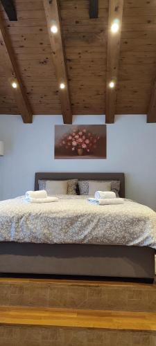 a bedroom with a large bed with wooden ceilings at House Zaterini in Korenica