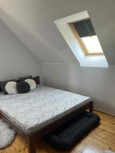 a bed in a room with a skylight at Domek kleszczewo in Miłki