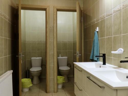 Un baño con dos inodoros y un lavabo. en Kauno Marių Vilos, en Samylai