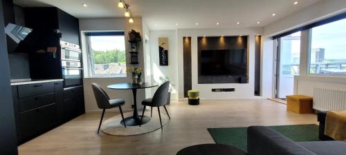 a kitchen and living room with a table and chairs at Penthouse in Kristiansand