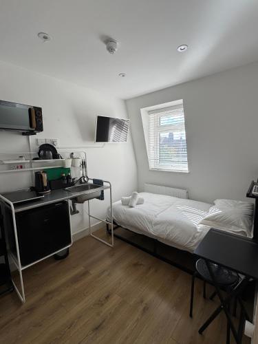a small room with a bed and a kitchen at Townhouse Studio with Kitchen & Ensuite - Great Location in London