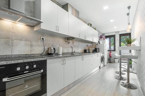 a kitchen with white cabinets and a stove top oven at Alojamento Amélie - Apartamento in Braga