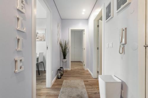 a hallway of a home with white walls and wooden floors at Alojamento Amélie - Apartamento in Braga