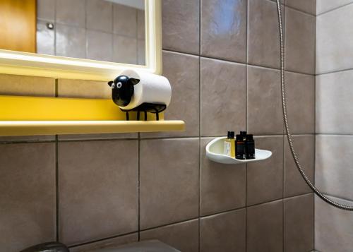 a bathroom with a toilet paper dispenser on a wall at Elation-rooms in Elatochori