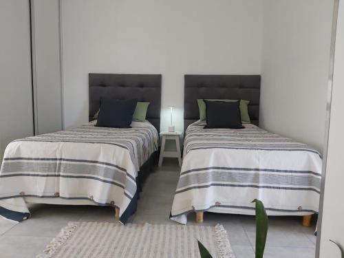 two beds sitting next to each other in a room at Monoambiente Italia in Venado Tuerto