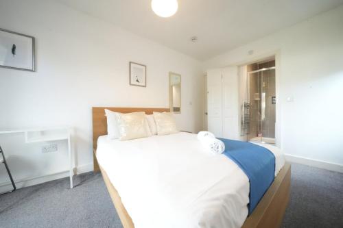 a bedroom with a large bed with white sheets and pillows at Great Airport Sleep PRIVATE bathroom in all ROOMS in Harmondsworth