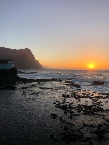 a sunset on the beach with the sun setting at Casa BB&Djassi - SUITES in Ponta do Sol