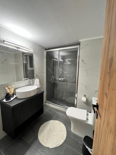 Un baño con dos lavabos y una ducha y un inodoro. en KN Luxury Apartment, en Alexandroupoli