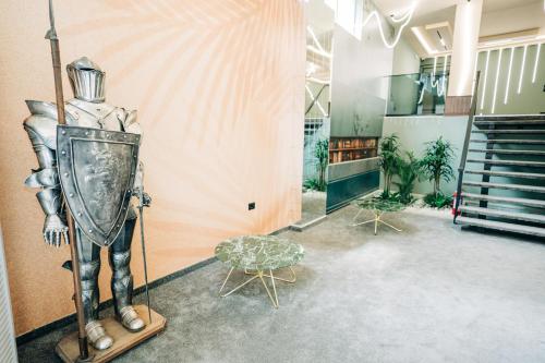 a room with a statue of a man wearing a armour at Noon Central Hotel in Tirana