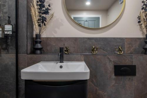 a bathroom with a white sink and a mirror at Modern 2-Bed Apt, Private Parking, Ayr Town Centre in Ayr