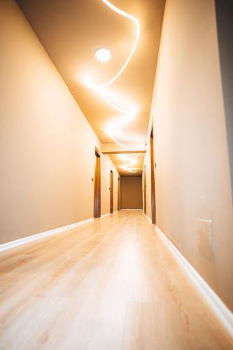an empty hallway of an empty room with wood floors at Noon Central Hotel in Tirana