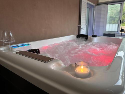 a white bath tub with a candle in it at Avi Rooms in Chiaramonte Gulfi