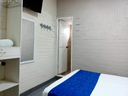 a small room with a bed and a door at Hotel Casa Boston Inn by Finerh in Barranquilla