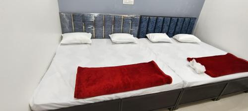 a large white bed with red sheets and pillows at Annapurna Hotel in Ujjain