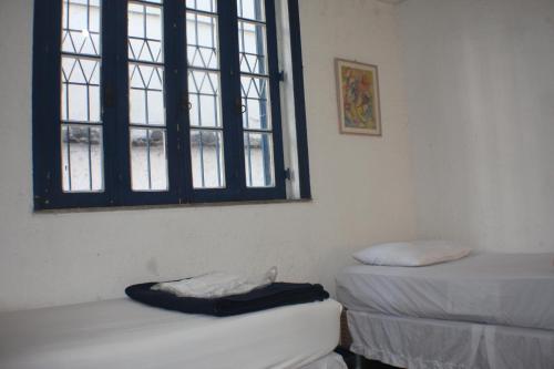 a room with two beds and a window at Farfalla Guest House in Rio de Janeiro