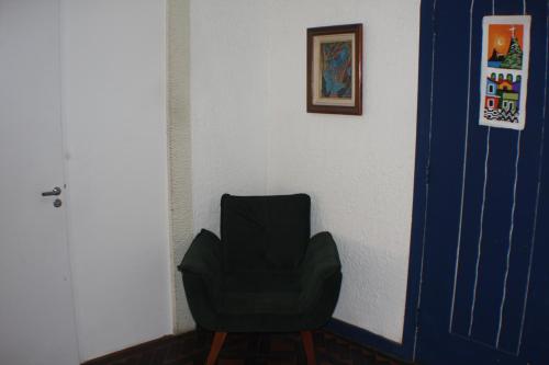 a black chair sitting in a room next to a wall at Farfalla Guest House in Rio de Janeiro