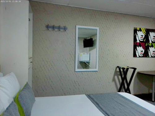 a bedroom with a white bed and a mirror at Hotel Casa Boston Inn by Finerh in Barranquilla
