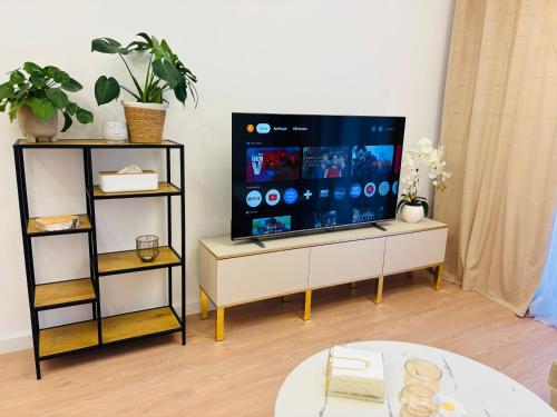 a living room with a flat screen tv on a stand at Lotus Apartments Impero oddzielna kuchnia 2 pokoje garaż in Ostrołęka