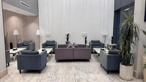 a waiting room with couches and tables and plants at شقق كيان للشقق المخدومة in Abha