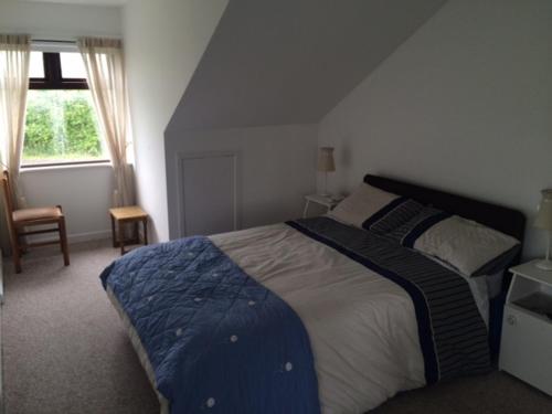 a bedroom with a large bed and a window at Greenfields Farmhouse in Ballylongford