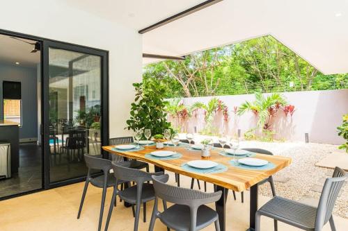 a dining room with a wooden table and chairs at Serenity Surf Villa in Playa Grande