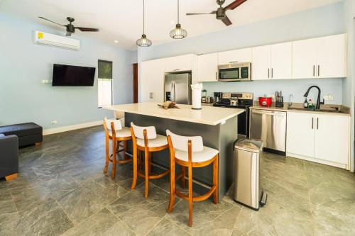 a kitchen with a large island with bar stools at Serenity Surf Villa in Playa Grande