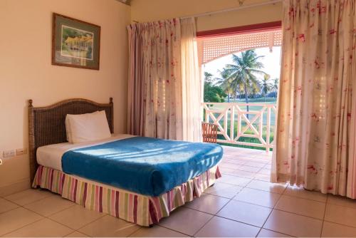 a bedroom with a bed and a large window at Caribbliss Suites in Lowlands