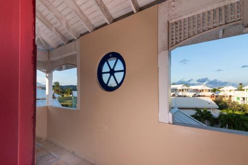 a clock on the side of a building with a window at Caribbliss Suites in Lowlands