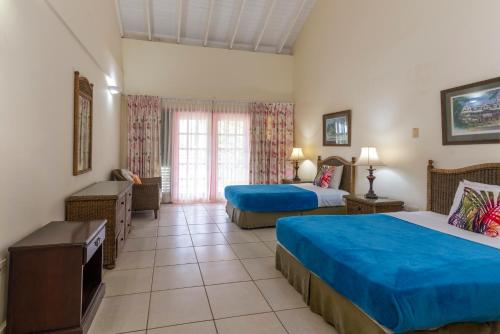 a hotel room with two beds and a window at Caribbliss Suites in Lowlands