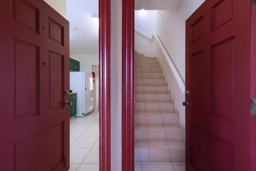 a hallway with red doors and stairs in a house at Caribbliss Suites in Lowlands