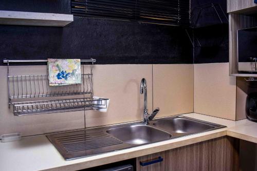 a kitchen counter with a sink and a towel at CozyHome Near Airport with pool gym and 24hour security in Boksburg