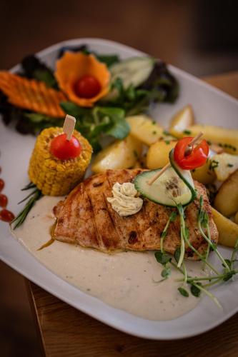 a plate of food with meat and vegetables on a table at Hotel Arkada in Levoča