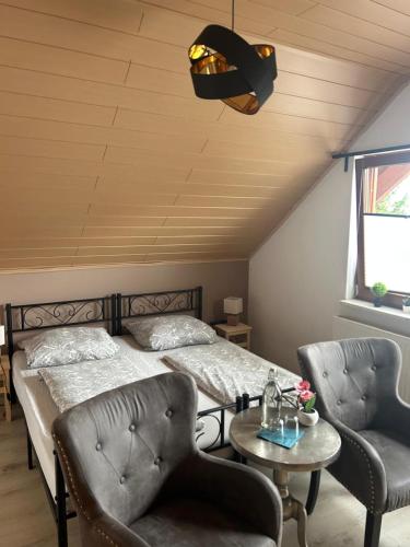 a bedroom with a bed and two chairs and a table at Pension Zum Paradies in Harthausen