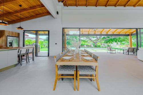 a dining room with a long wooden table and chairs at Casa Nimbu - Hacienda Pinilla in Playa Avellana