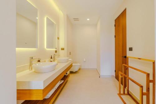 a bathroom with two sinks and two toilets at Casa Nimbu - Hacienda Pinilla in Playa Avellana