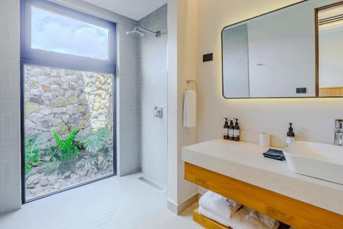 a bathroom with a sink and a large window at Casa Nimbu - Hacienda Pinilla in Playa Avellana