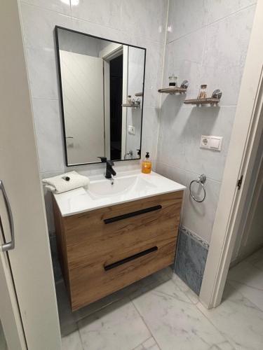 a bathroom with a sink and a mirror at Bonito apartamento de la playa in Villajoyosa